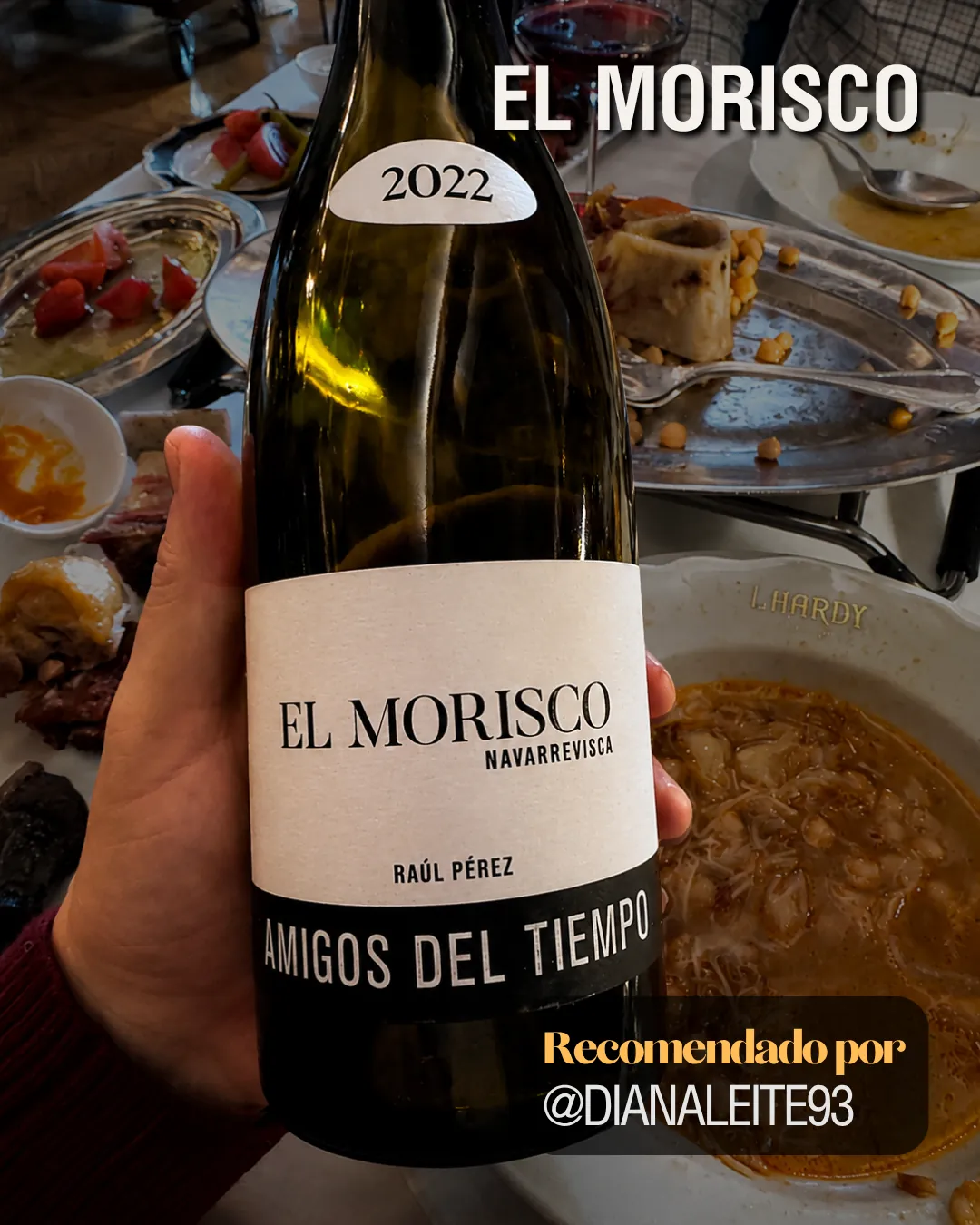 Mano sosteniendo una botella de El Morisco 2022 de Raúl Pérez durante una comida